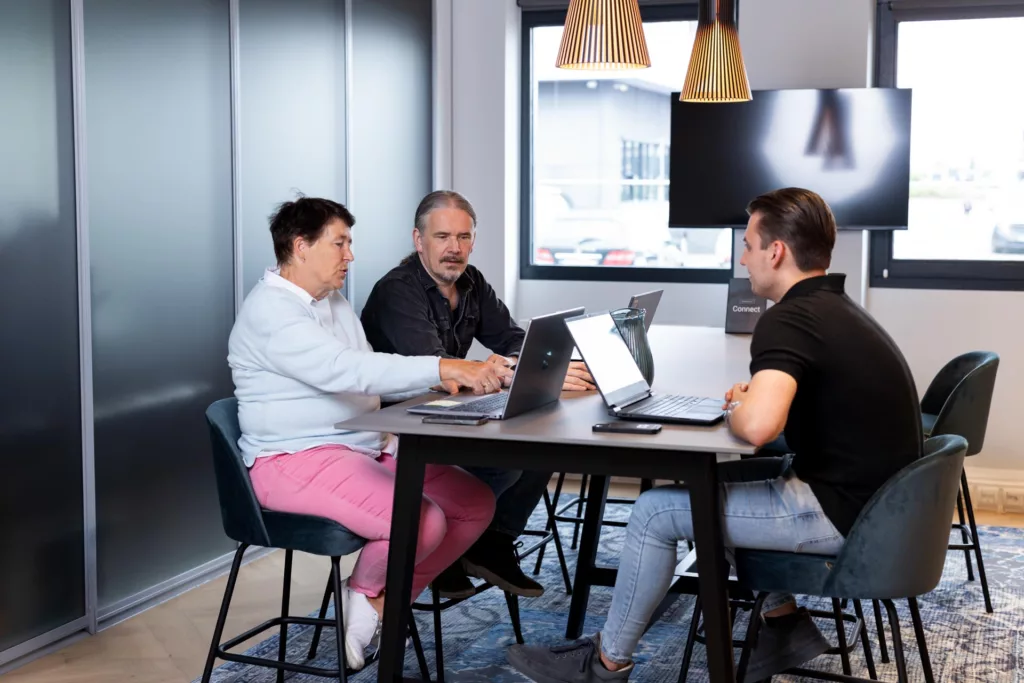 Irma Roetenberg wijst tijdens overleg over Dynamics 365, samen met Dyon Grob en Richard Ludwig bij Msquad