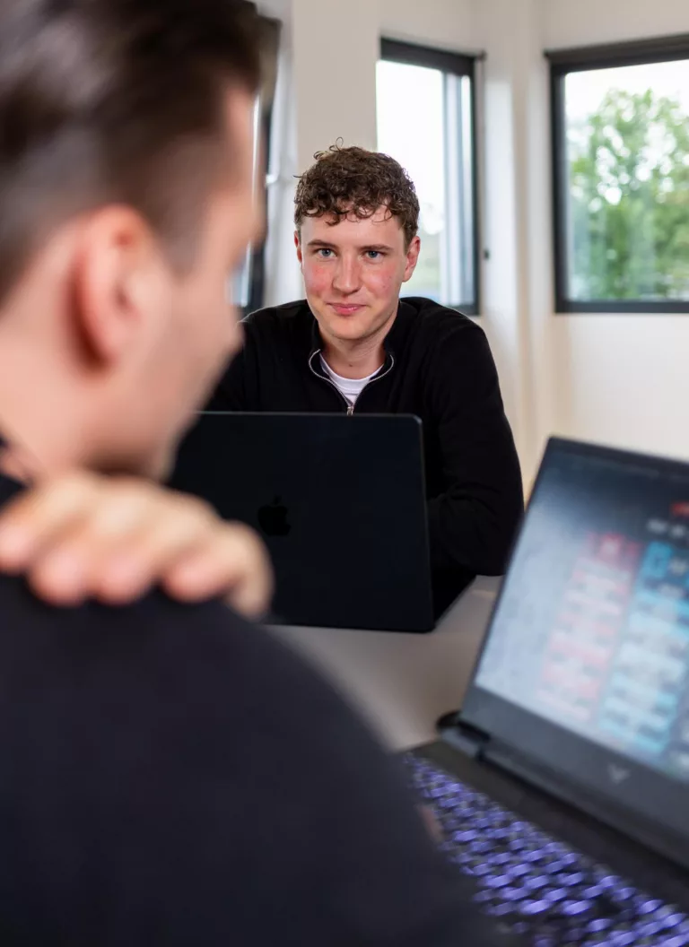 Bob Beissel kijkt naar Dyon Grob tijdens technische afstemming op kantoor bij Msquad